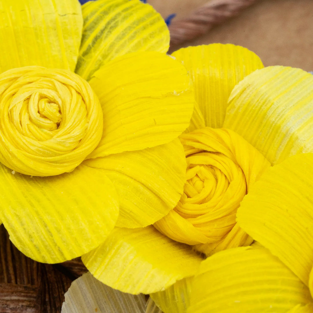 Yellow cornhusk flowers on a brown surface