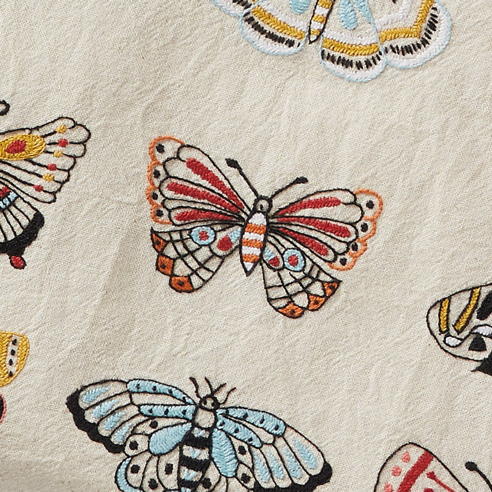 Close-up of embroidered butterflies on a textured fabric background