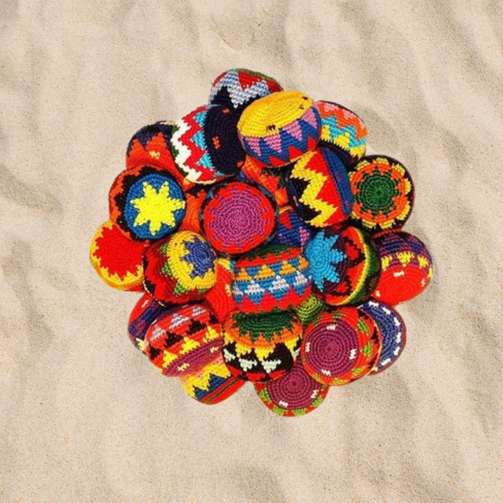 A group of footbags in the sand