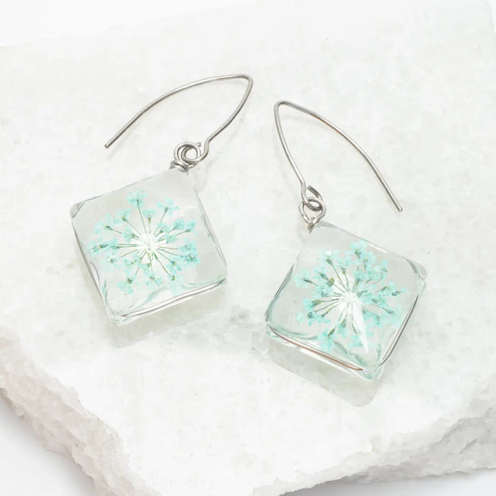 Square earrings with floral design on a white background