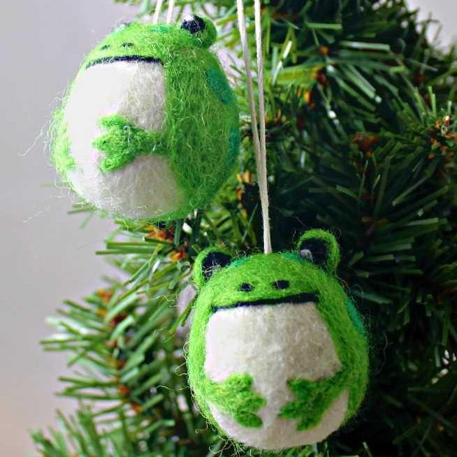 Frog ornaments hanging on Christmas tree 