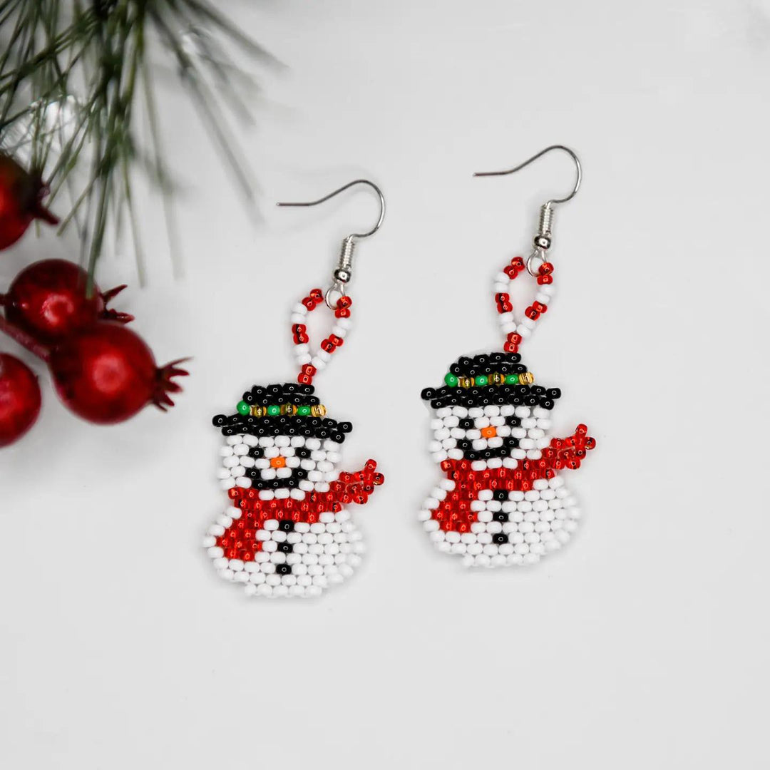 Beaded snowman earrings with Christmas decorations on a light background