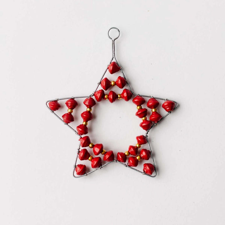 Star-shaped ornament with red paper beads on a white background
