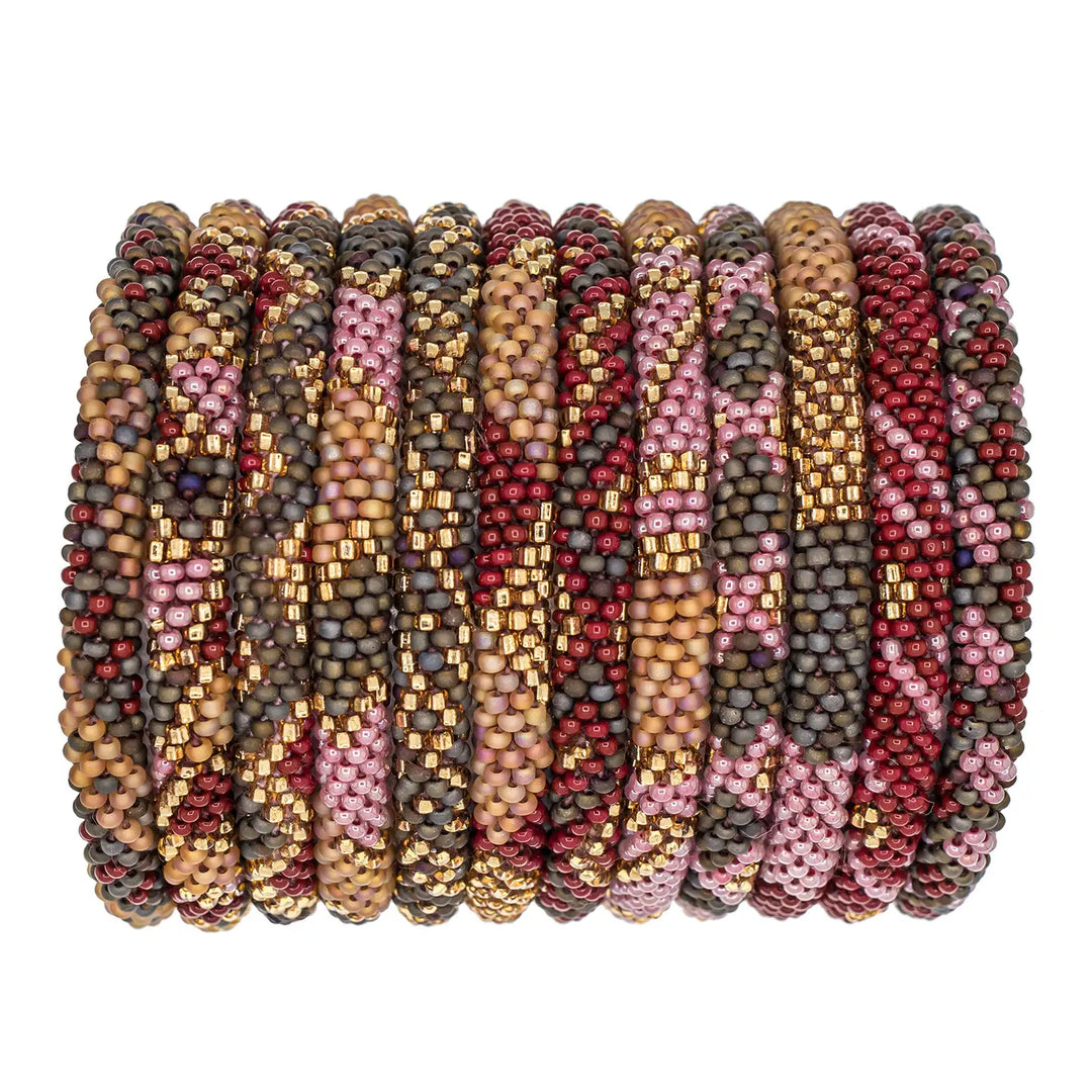 A stack of ten beaded bangles with intricate geometric and tribal patterns in pink, gold, brown, and red, arranged horizontally on a plain white background.