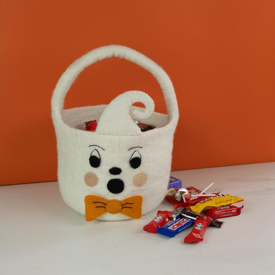 Halloween-themed candy basket with face design on an orange background