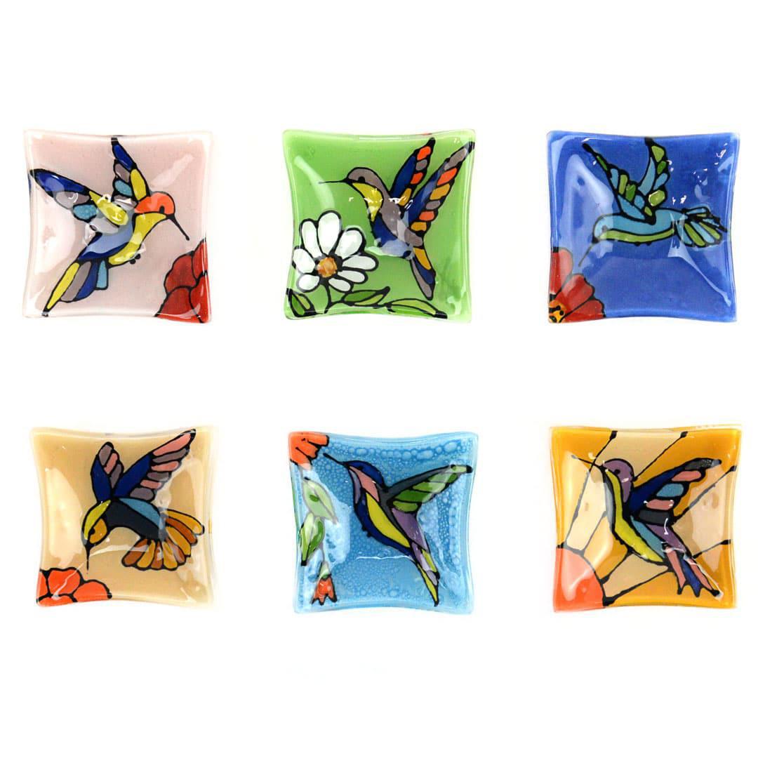 A collection of hand-painted glass dishes featuring various colorful hummingbird designs.