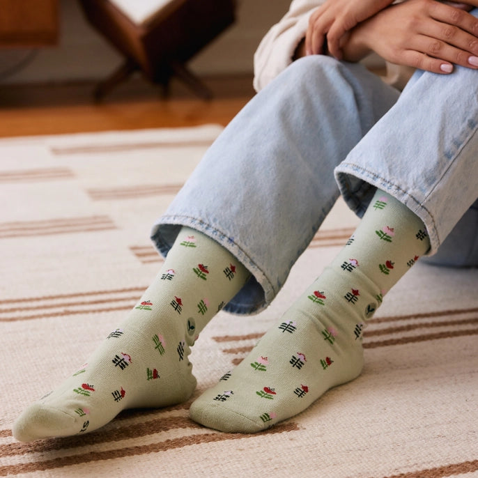 a person wearing Conscious Step green crew socks with tulips o