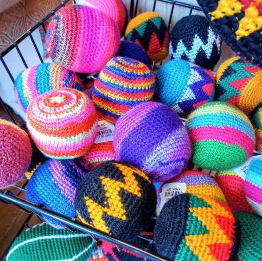 Colorful crocheted hacky sack balls in a basket