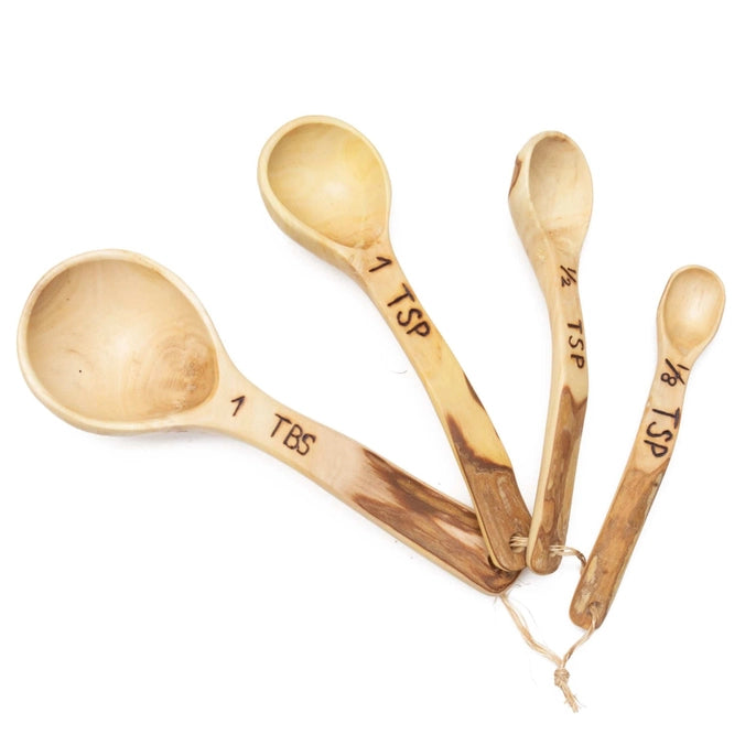 Set of wooden measuring spoons with measurements on a white background
