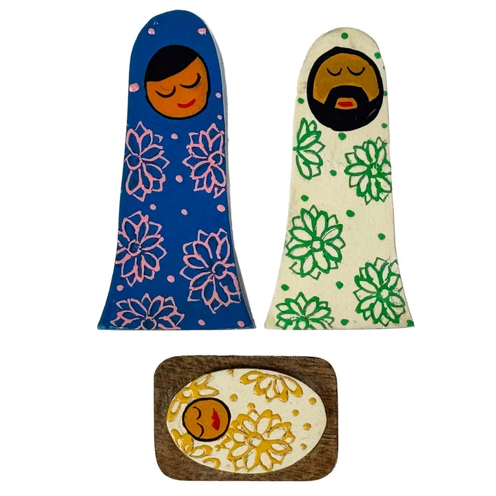 Three wooden dolls with floral patterns on a white background