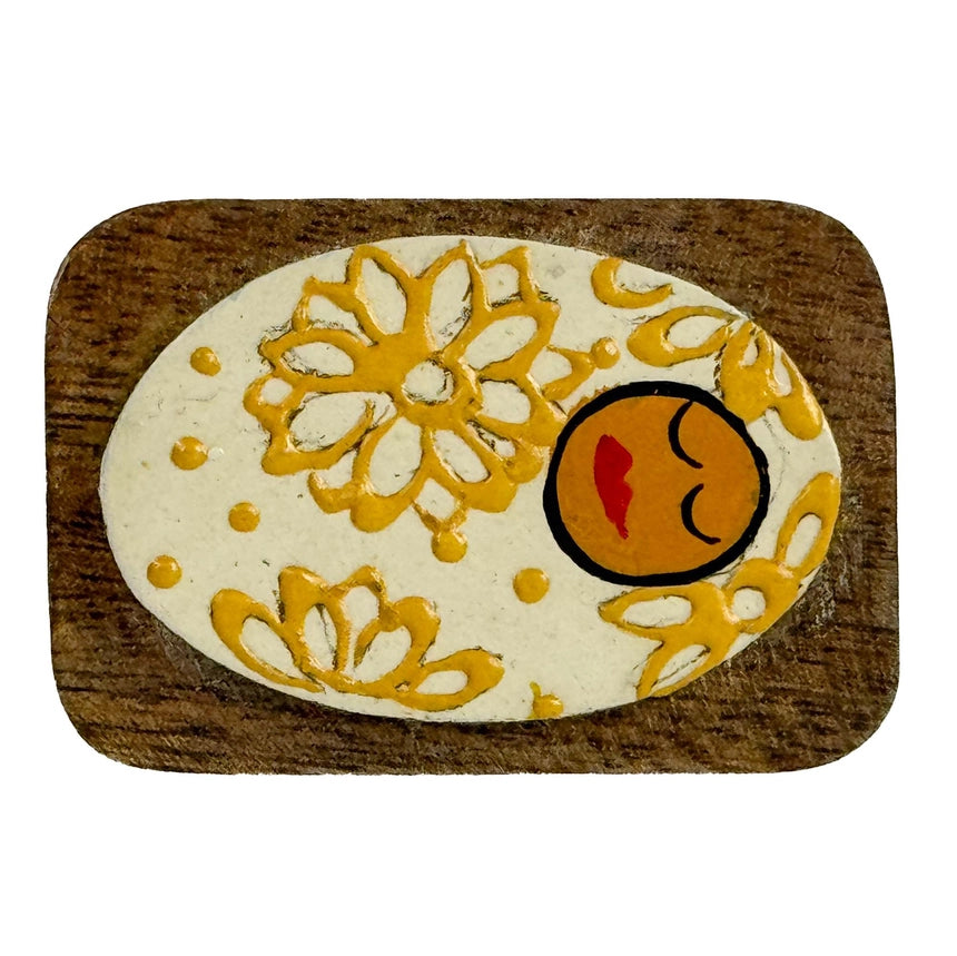 Decorative Baby Jesus with yellow floral patterns on a wooden base