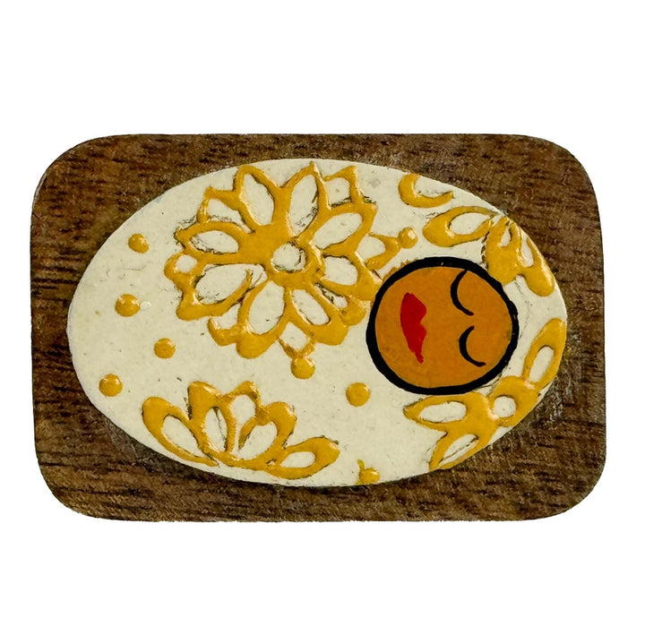 Decorative Baby Jesus with yellow floral patterns on a wooden base