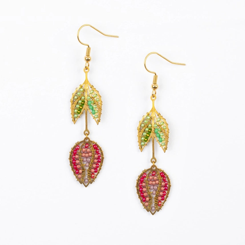 Tulip-shaped gold earrings with green and pink beads on a white background
