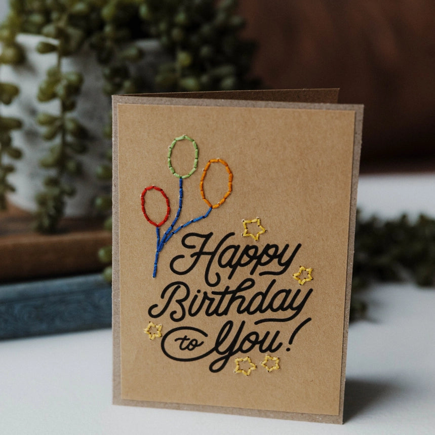 Kraft paper card with hand stitched embroidered balloons and stars.  Printed with Happy Birthday to You! 
