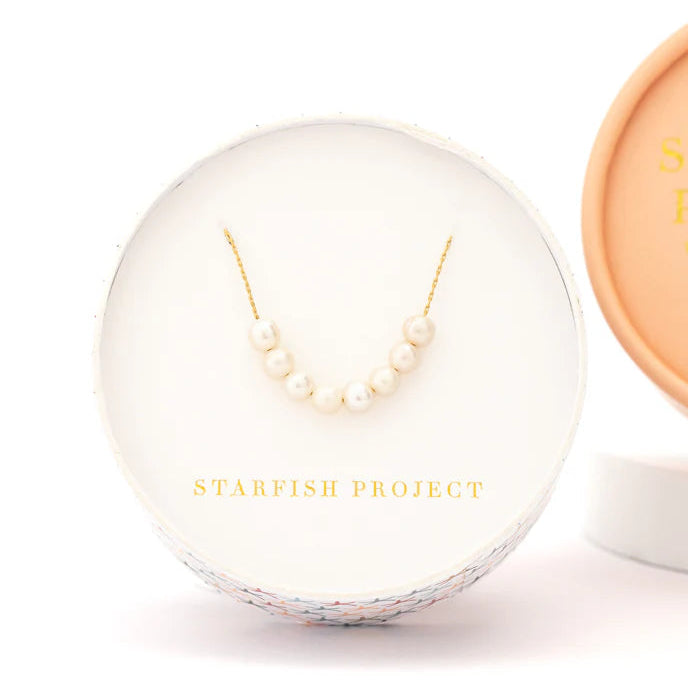 Pearl necklace in a clear display case with 'Starfish Project' branding on a white background