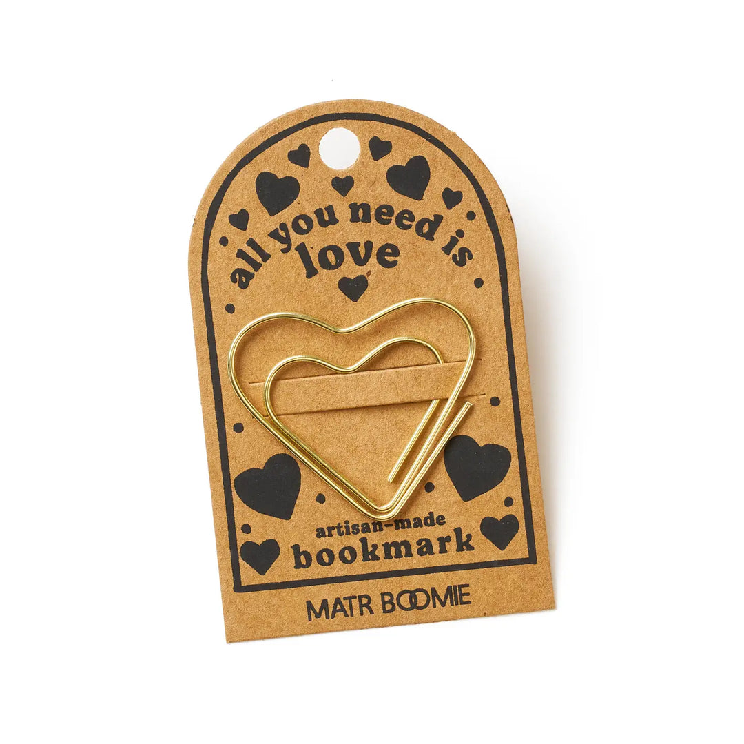 Heart-shaped gold bookmark on a brown card with 'all you need is love' text, on a white background.