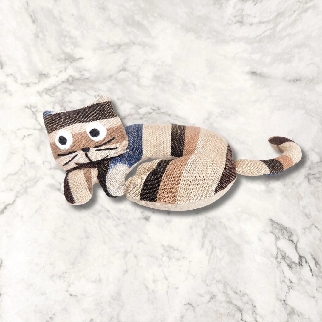 Cat-shaped cat trivet on a textured white surface