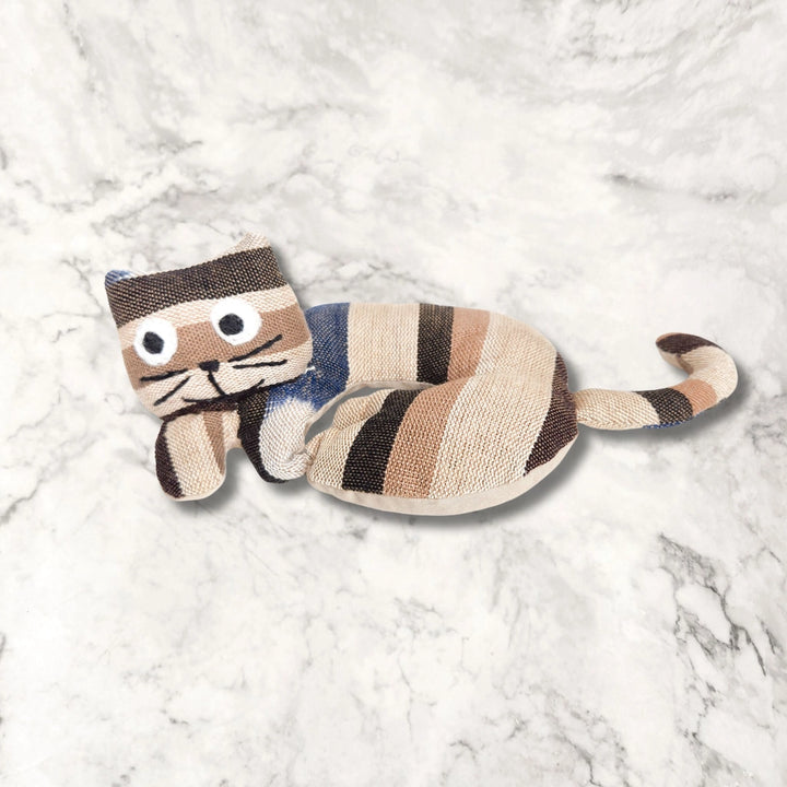 Cat-shaped cat trivet on a textured white surface