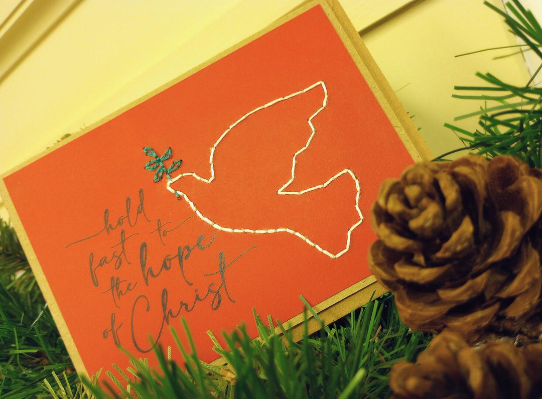 Red card with white dove and text 'hold fast the hope of Christ' 