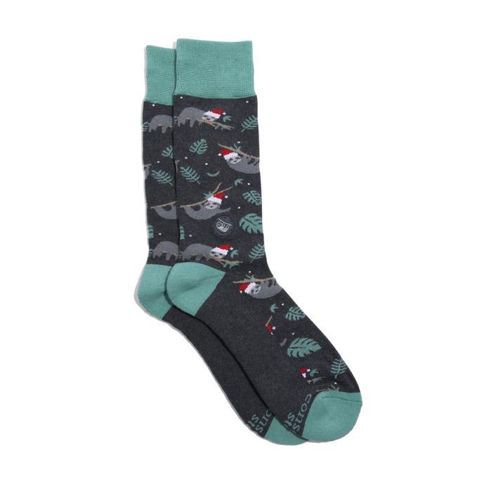 A pair of holiday socks with a sloth design, featuring green color and patterns related to sloths, Santa Claus, and Christmas.