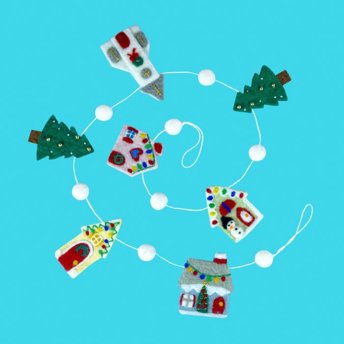 Decorative string with gingerbread house and tree ornaments on a blue background