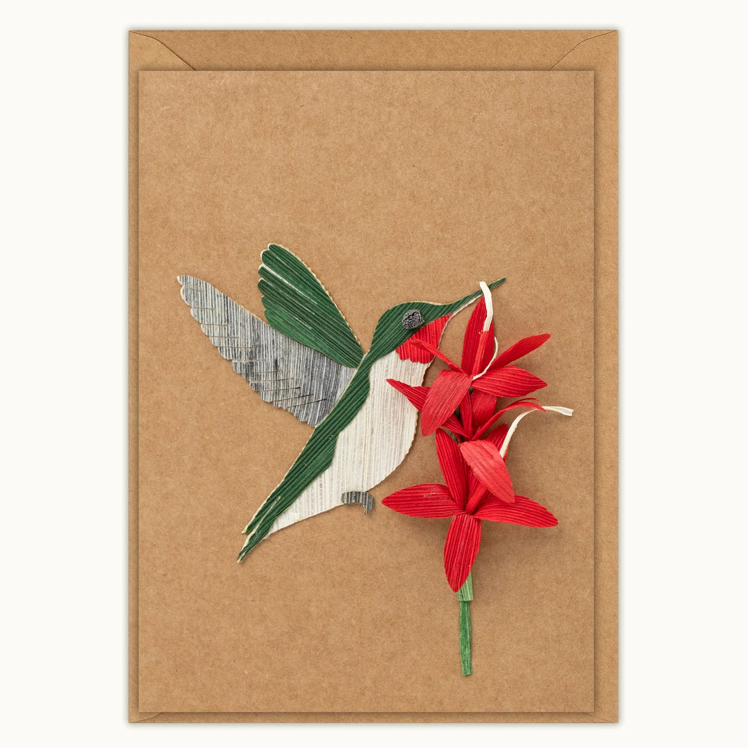 Card with a cutout of a hummingbird and red flowers on a brown background