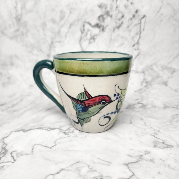 Decorative mug with a hummingbird design on a marble surface