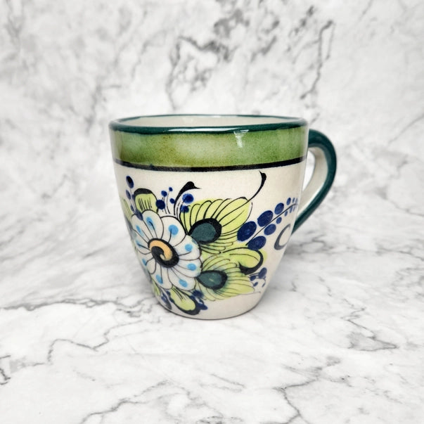 Decorative ceramic mug with floral pattern on a marble surface