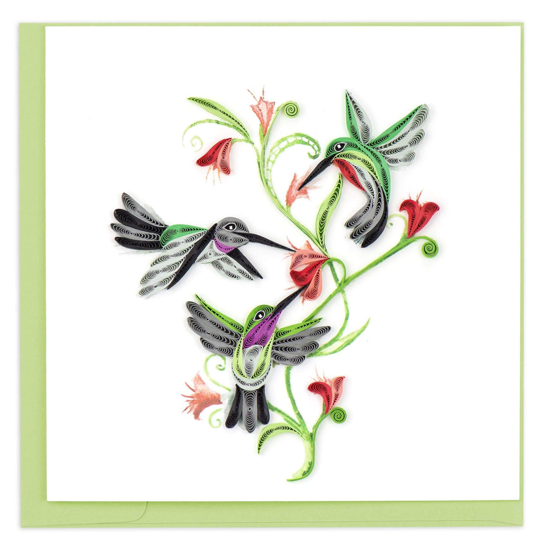 A greeting card featuring a quilled design of three hummingbirds around floral motifs, with a green envelope.