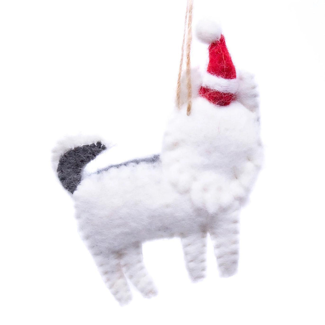 White dog-shaped ornament with a red bow on a white background