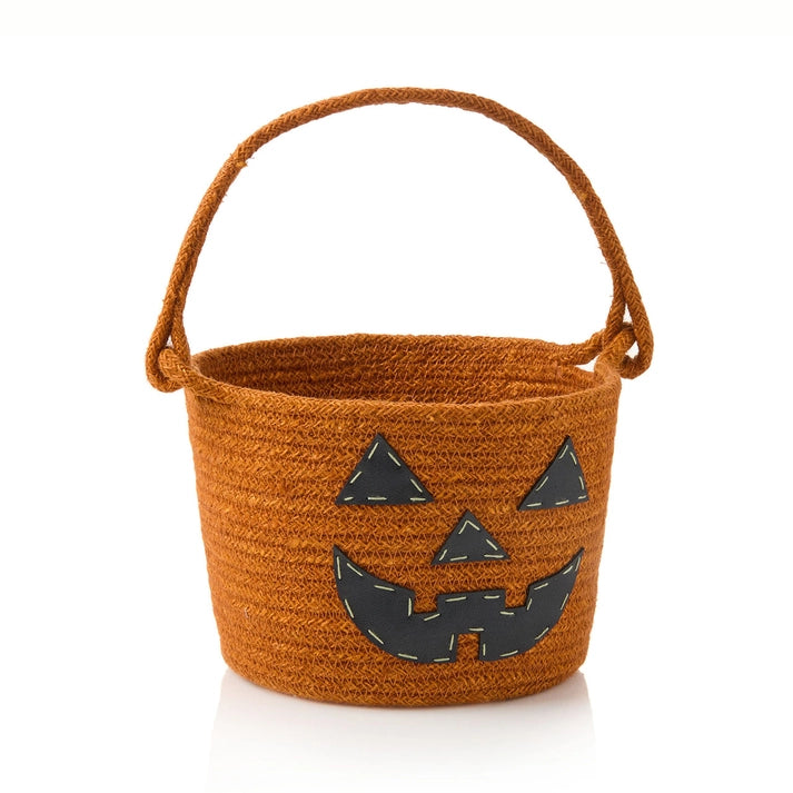 Brown woven Halloween bucket with a jack-o'-lantern face on a white background