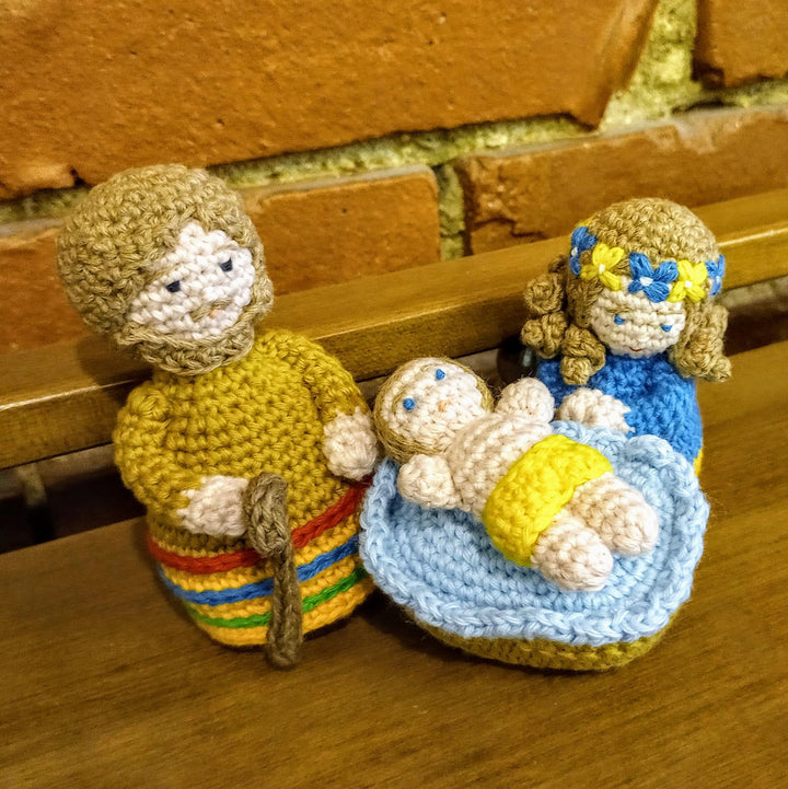 Nativity scene with crocheted figurines of Jesus, Mary, and Joseph. 