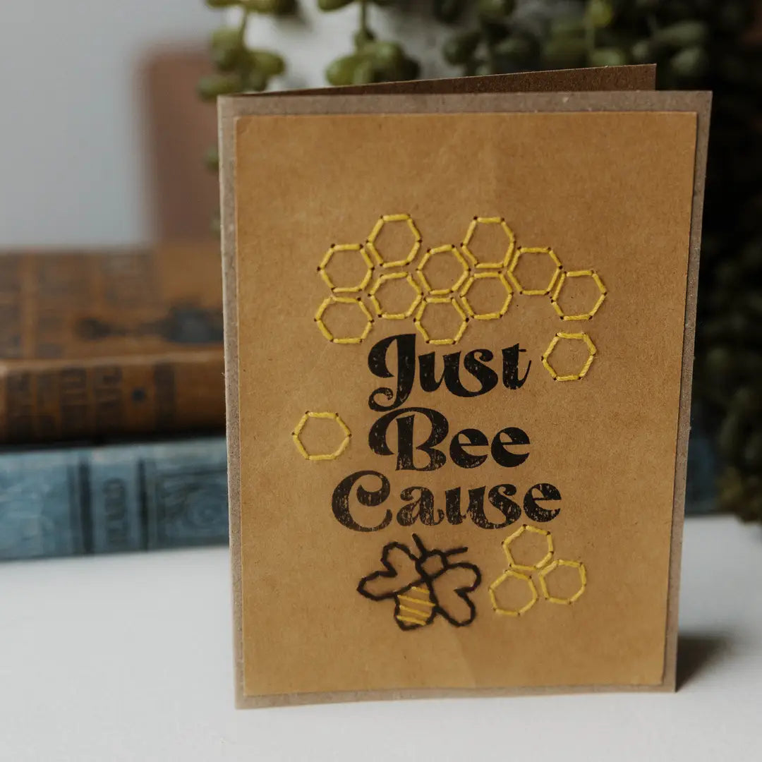 Card with embroidered design of honeycomb and bee, text 'Just Bee Cause', on a brown background.