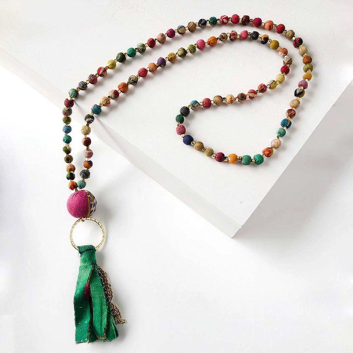 Colorful Kantha beaded necklace with a tassel on a white background