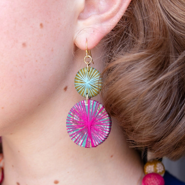 Close-up of a person wearing colorful Kantha earrings