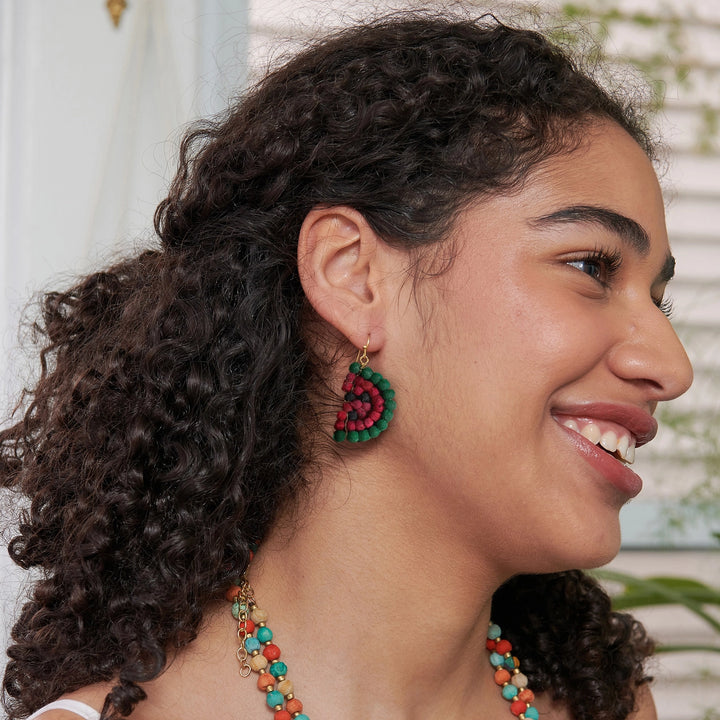 Woman wearing watermelon-shaped colorful beaded earrings