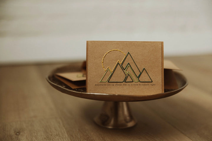 Brown card with mountain design on a metal stand