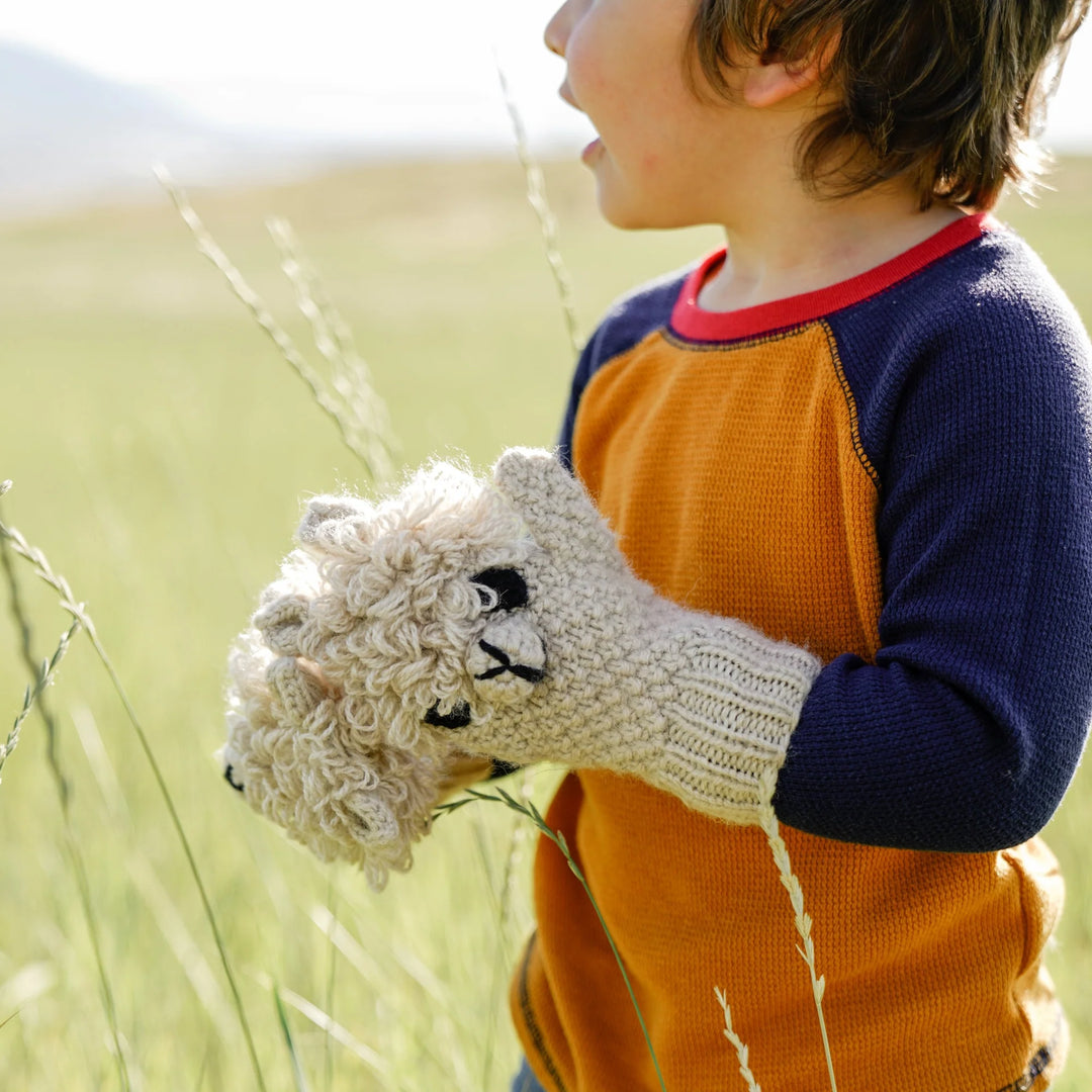 A boy wearing alpaca animal mittens