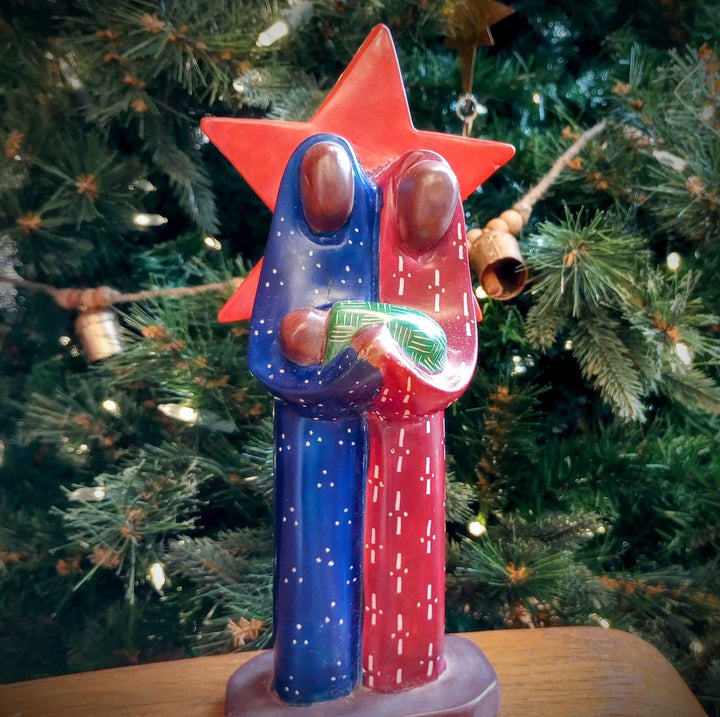 Colorful Kisi stone nativity scene with a red star behind Joseph and Mary.