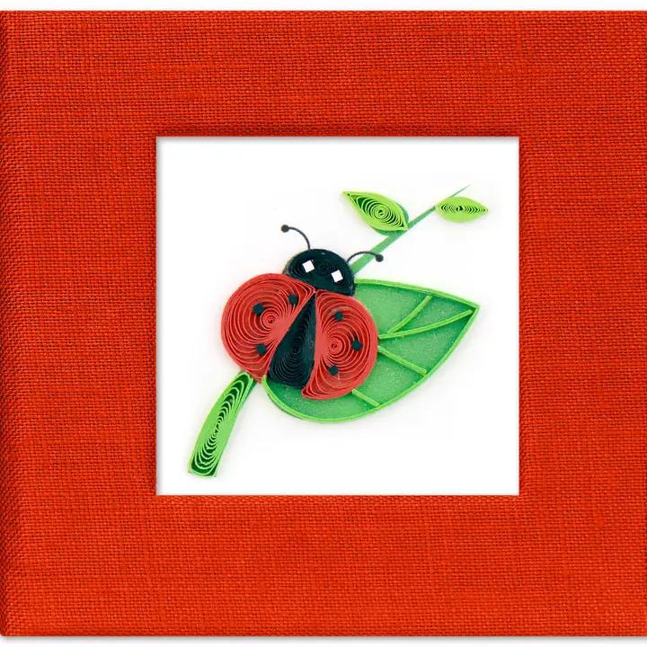 Quilled ladybug and leaf quilled sticky note cover a white background with a red border 