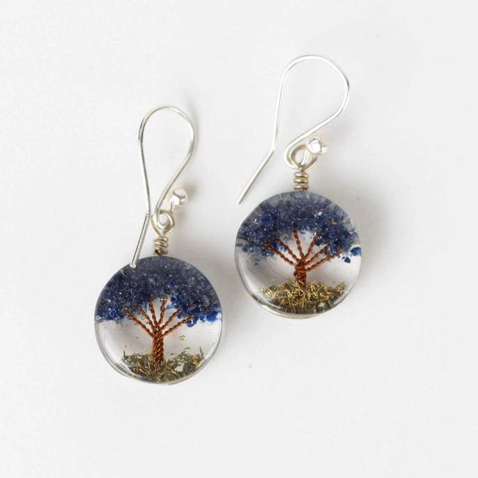 Pair of earrings with tree design on a white background