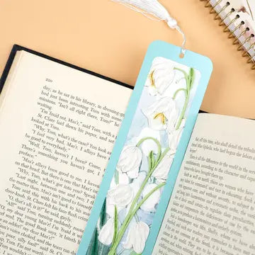 Floral bookmark on an open book with a notebook in the background
