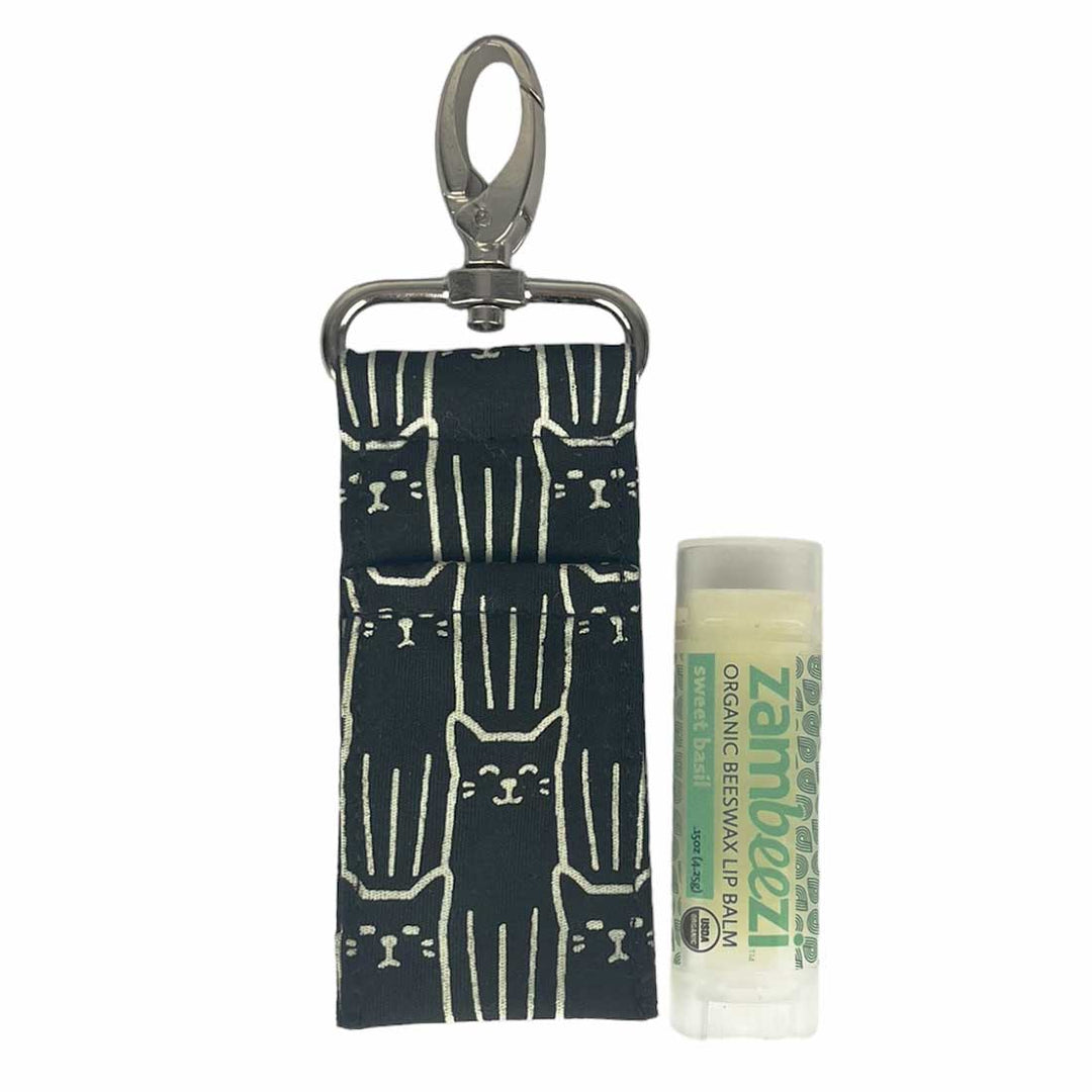 Lip balm with a cat patterned pouch and clip on a white background