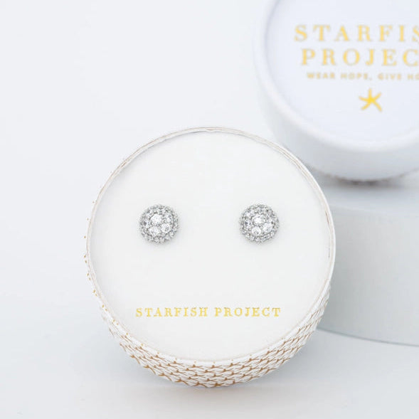 Silver earrings in a round box with 'Starfish Project' branding on a white background
