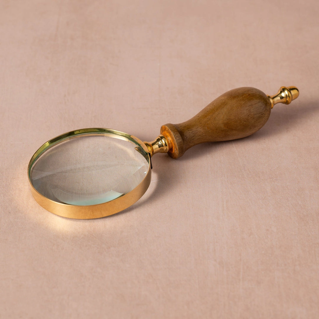 Magnifying glass with wooden handle on a beige background