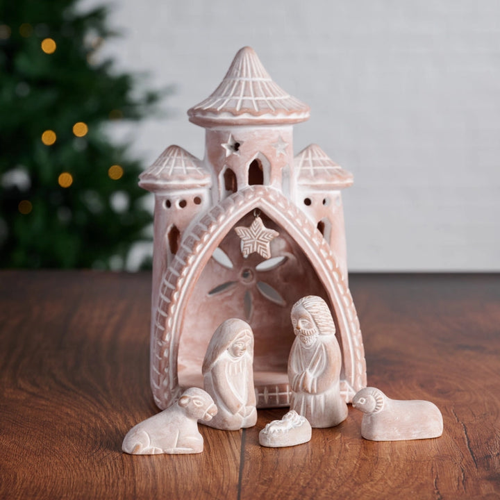 Decorative nativity scene with a castle-like structure on a wooden surface.
