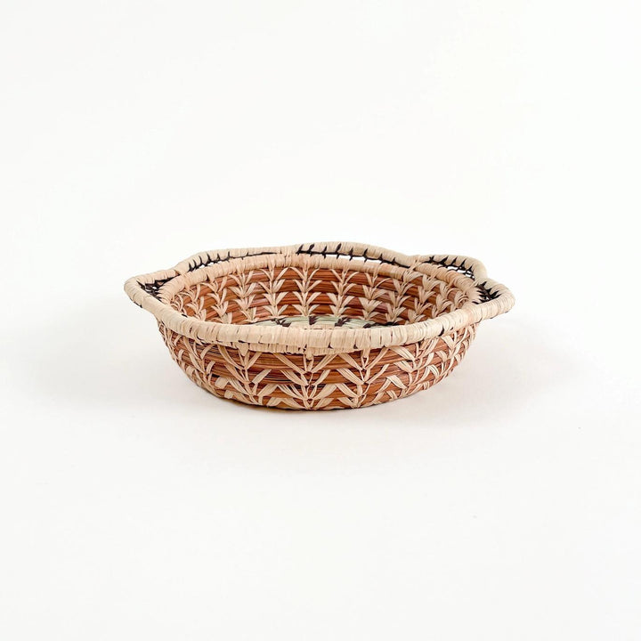 Woven basket with a leaf pattern on a white background