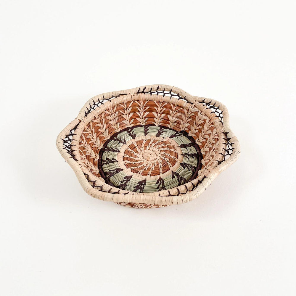 Woven basket with a decorative pattern on a white background