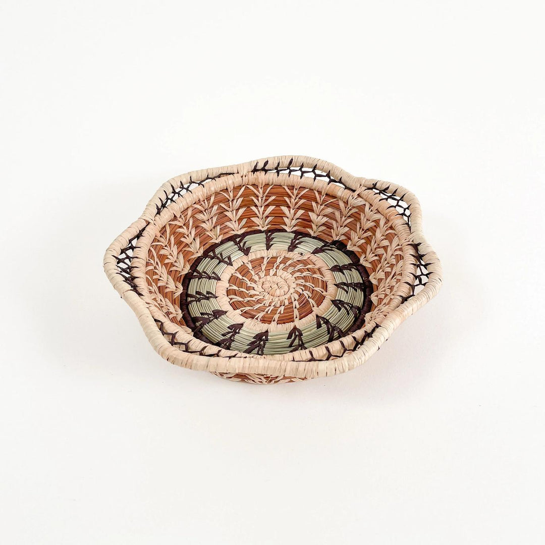 Woven basket with a decorative pattern on a white background