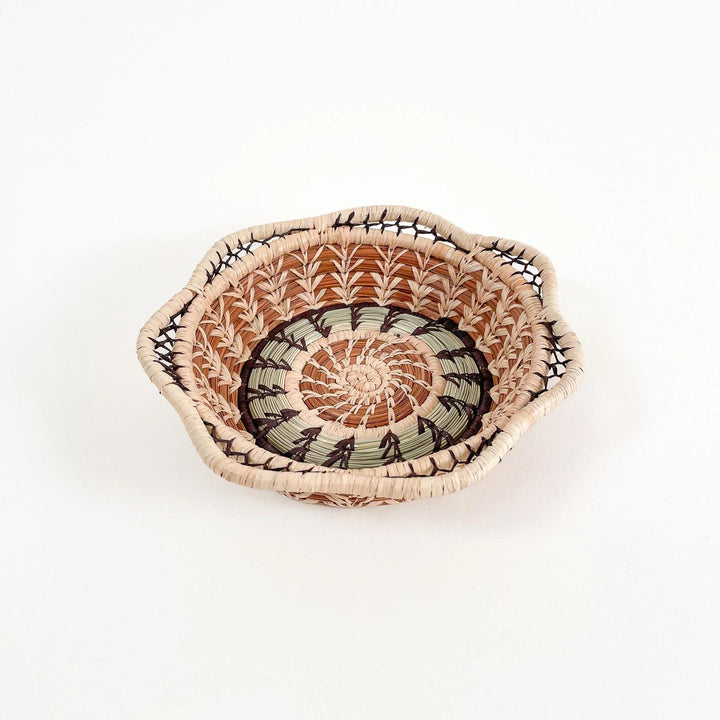Woven basket with a decorative pattern on a white background